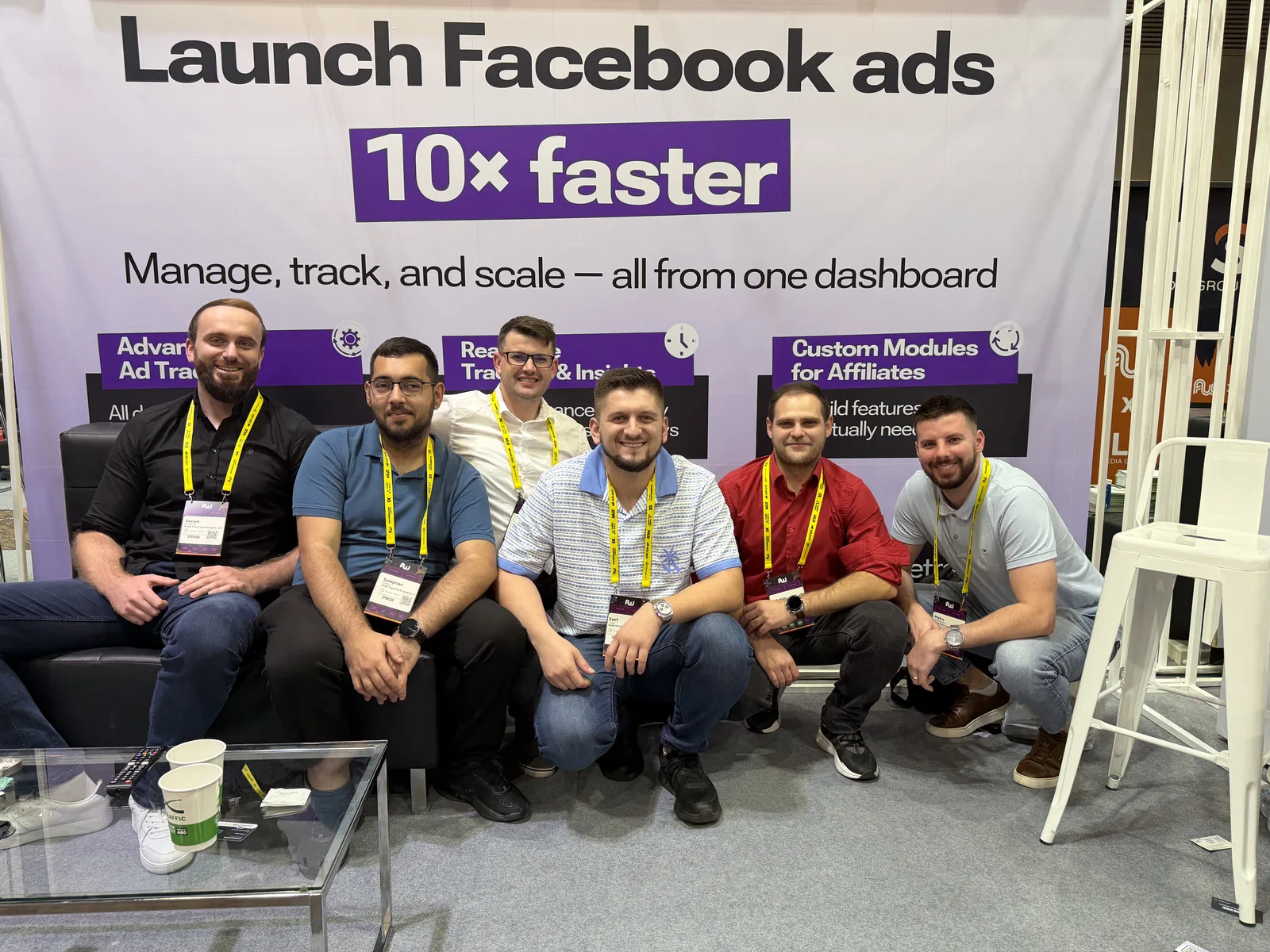 Six attendees posing together in front of the ScaleTrack booth backdrop.