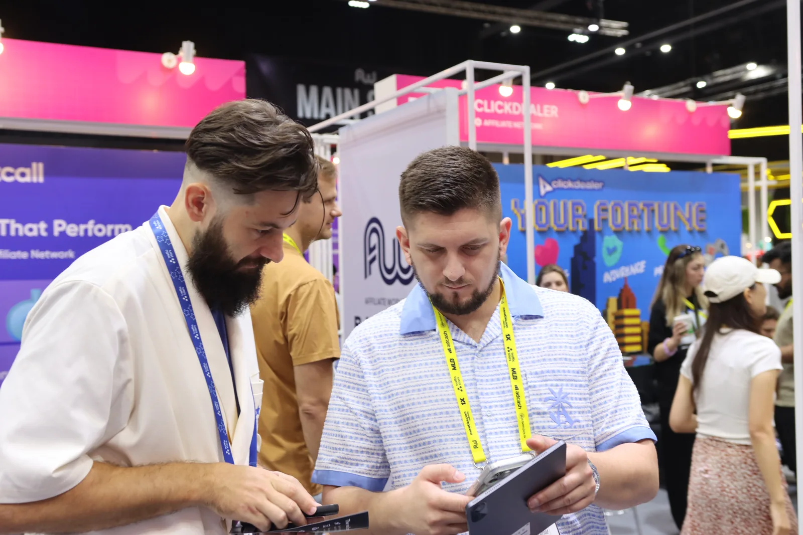 Two attendees looking at a tablet on the exhibition floor.
